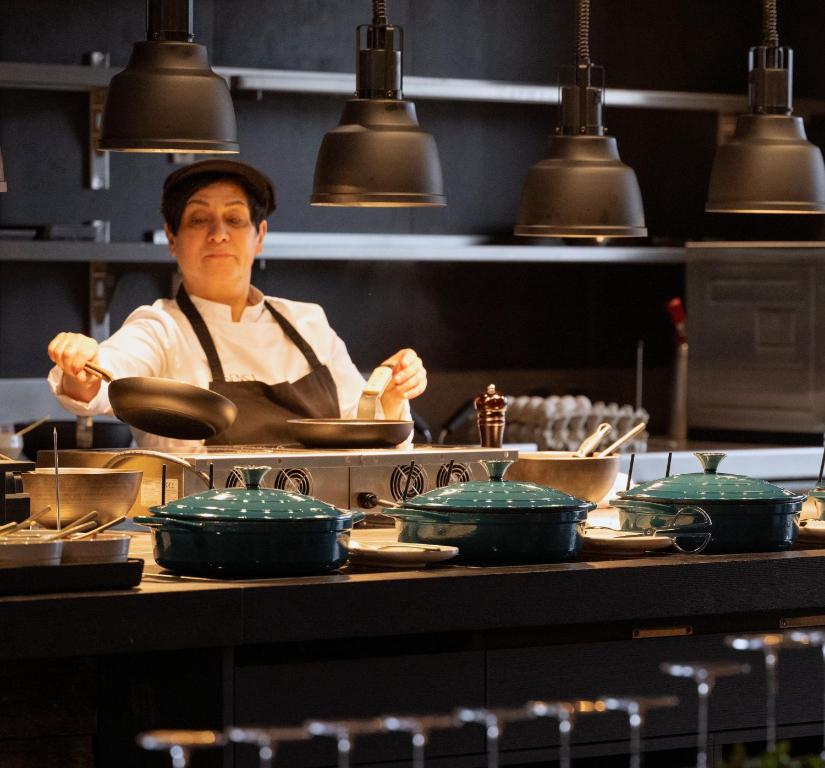 a chef preparing food in a restaurant kitchen at Anatura Luxembourg in Weiswampach