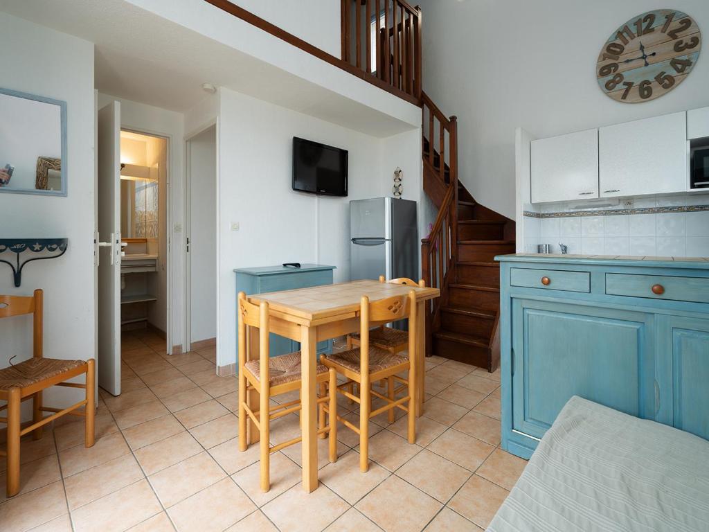 une cuisine avec une table et un meuble bleu dans l'établissement Samaria Village N11 - 2P6, au Cap d'Agde