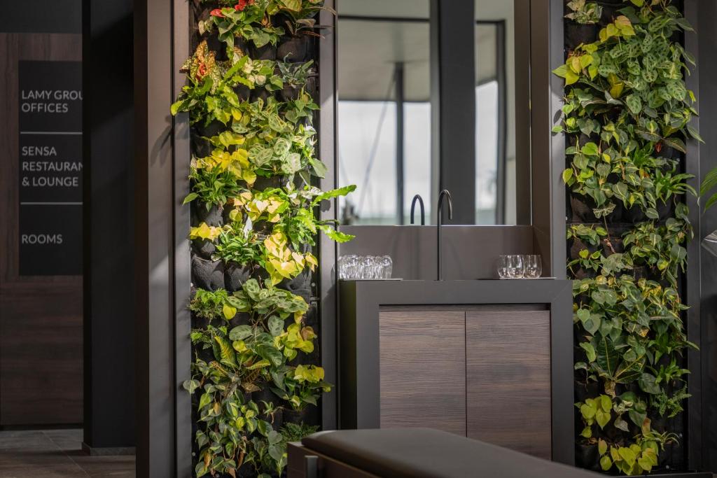 a bathroom with a green wall with flowers at Anatura Luxembourg in Weiswampach