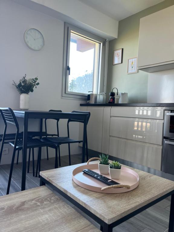 - une cuisine avec une table et une télécommande dans l'établissement Appartement T2 vue mer, à Cabourg