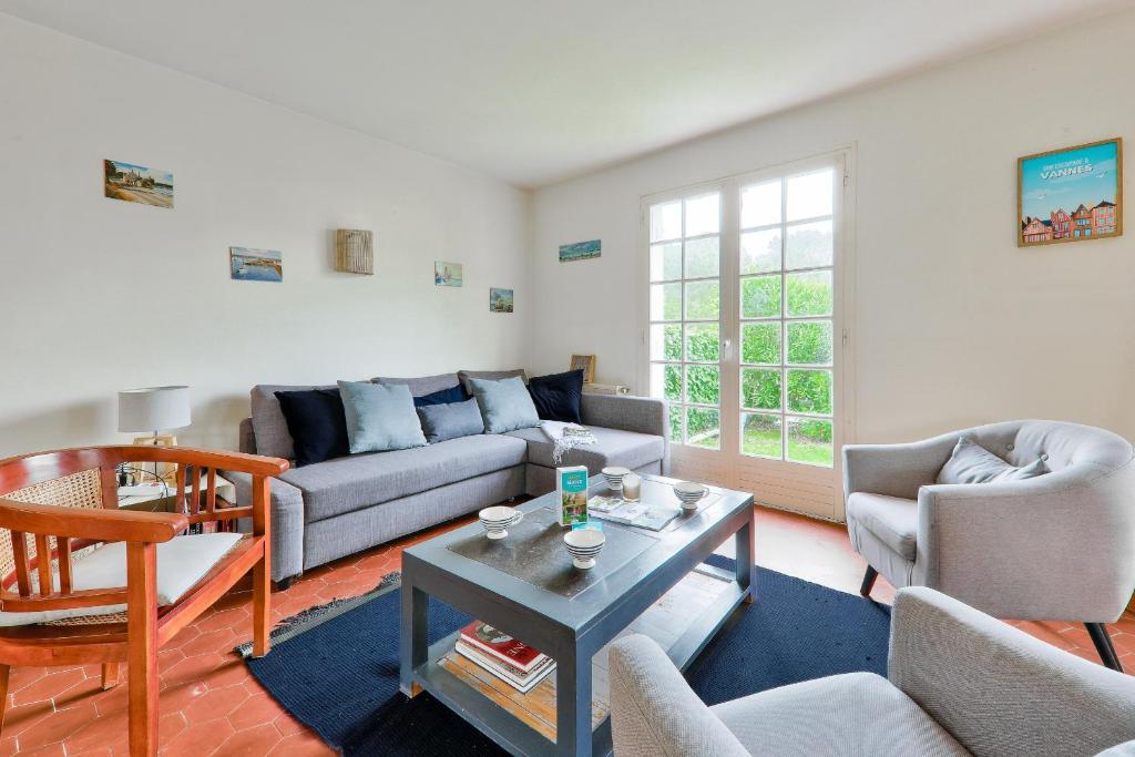 un salon avec un canapé, des chaises et une table dans l'établissement Maison pour 8 avec jardin, 300 m de la mer, à Saint-Gildas-de-Rhuys