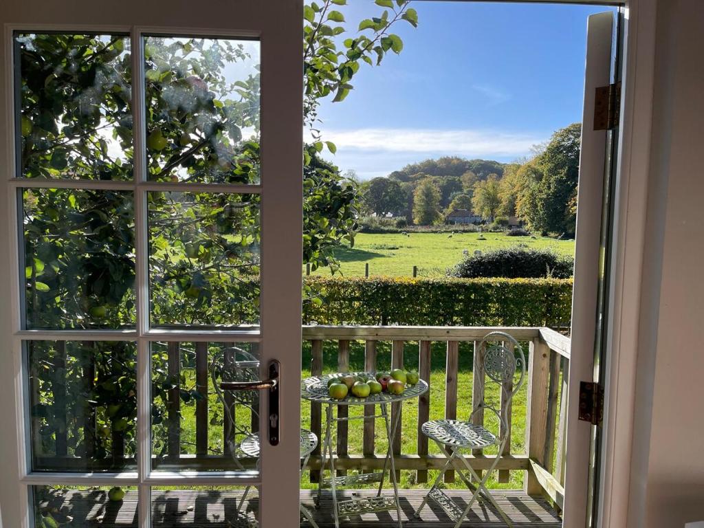 an open door to a balcony with a view of a field at The Parcel Shed Gilling East in Gilling East