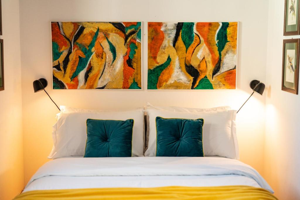 a bed with two pillows and a painting above it at Via Cesarini Apartment in San Vito al Tagliamento