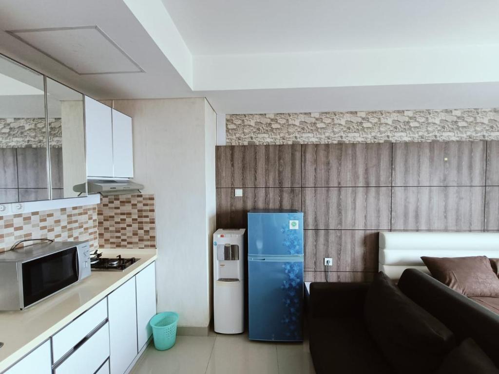 a small kitchen with a blue refrigerator in a room at Chiens168 in Cikarang