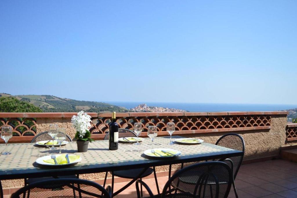 - une table avec des verres à vin sur le balcon dans l'établissement Villa 5 pièces 8 couchages BANYULS SUR MER BN000-A03, à Banyuls-sur-Mer