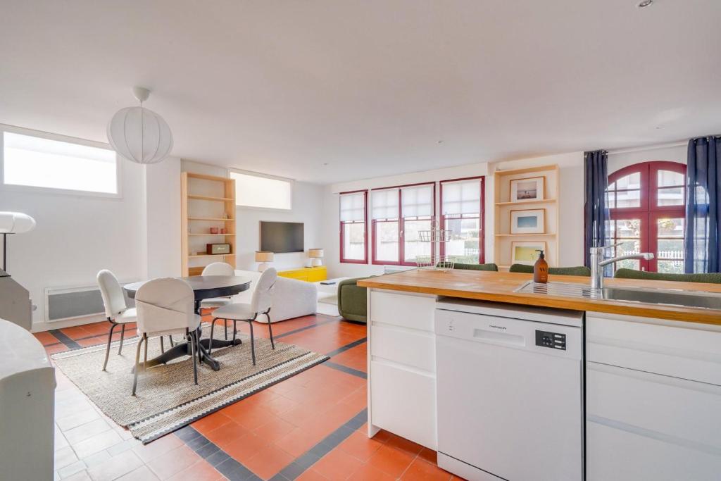 une cuisine et un salon avec une table et des chaises dans l'établissement Centre du Moulleau -Apt Voile au Vent- 5 minutes à pied de la plage, à Arcachon