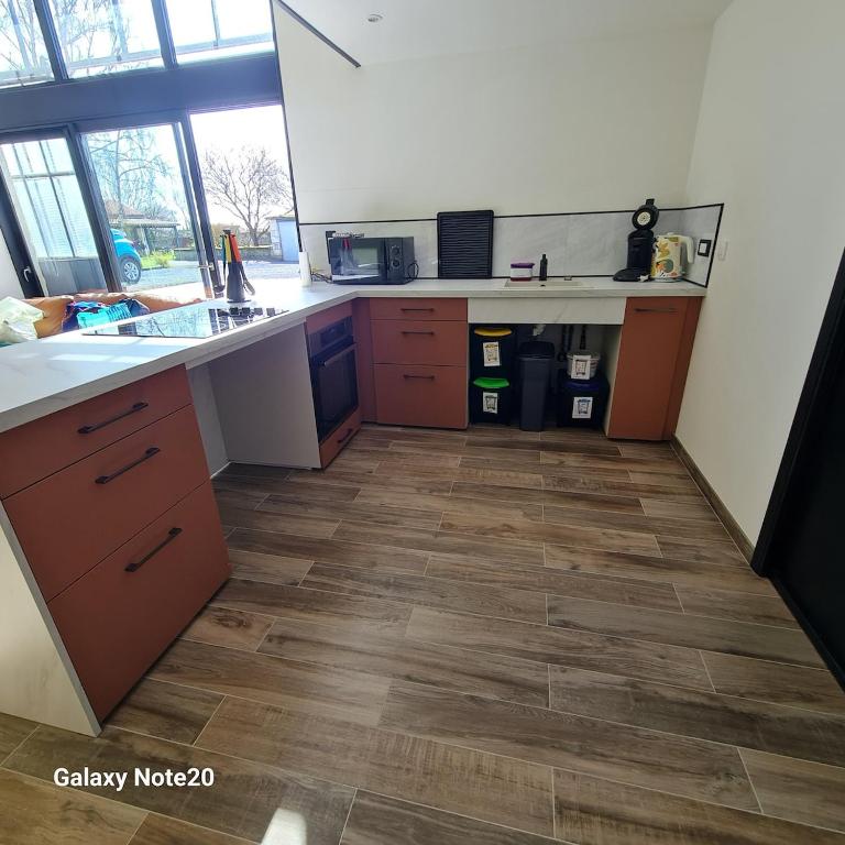Il comprend une cuisine dotée de parquet et d'un comptoir. dans l'établissement Gite PMR Adapté Futuroscope Aquascope Center Parc Mecanick & Ko, à Mirebeau