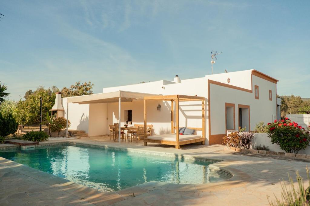 a villa with a swimming pool in front of a house at Casa Mariposa Benirras in Sant Miquel de Balansat