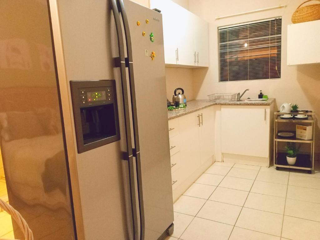 a kitchen with a stainless steel refrigerator at Sugarbird Nest in East London