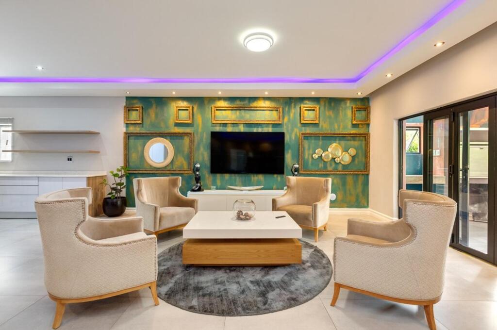 a living room with a table and chairs at Braham Lodge - The Octave 3 in Johannesburg