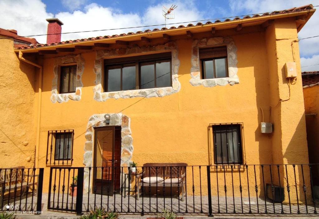 a yellow house with a fence in front of it at Los Callejos - Casita for 4 people - 3 bedrooms in Los Callejos