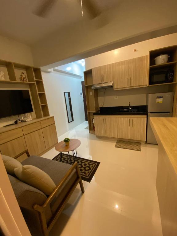 a kitchen and living room with a couch and a table at Jono's Flat Royal Oceancrest in Lapu Lapu City