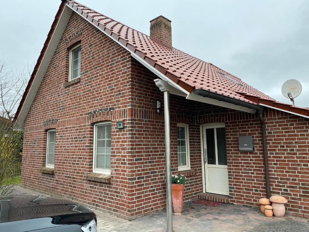 a red brick house with a red roof at Neuhaus Deichperle in Krummhörn
