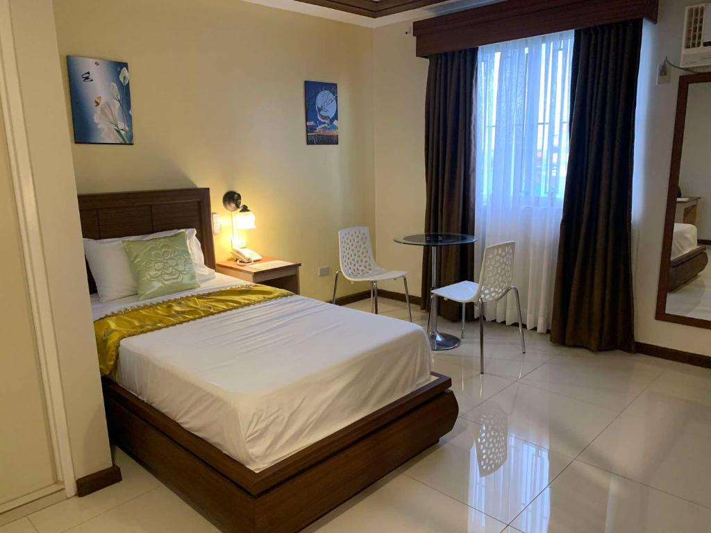 Postel nebo postele na pokoji v ubytování Surigao Royal Regency Suites