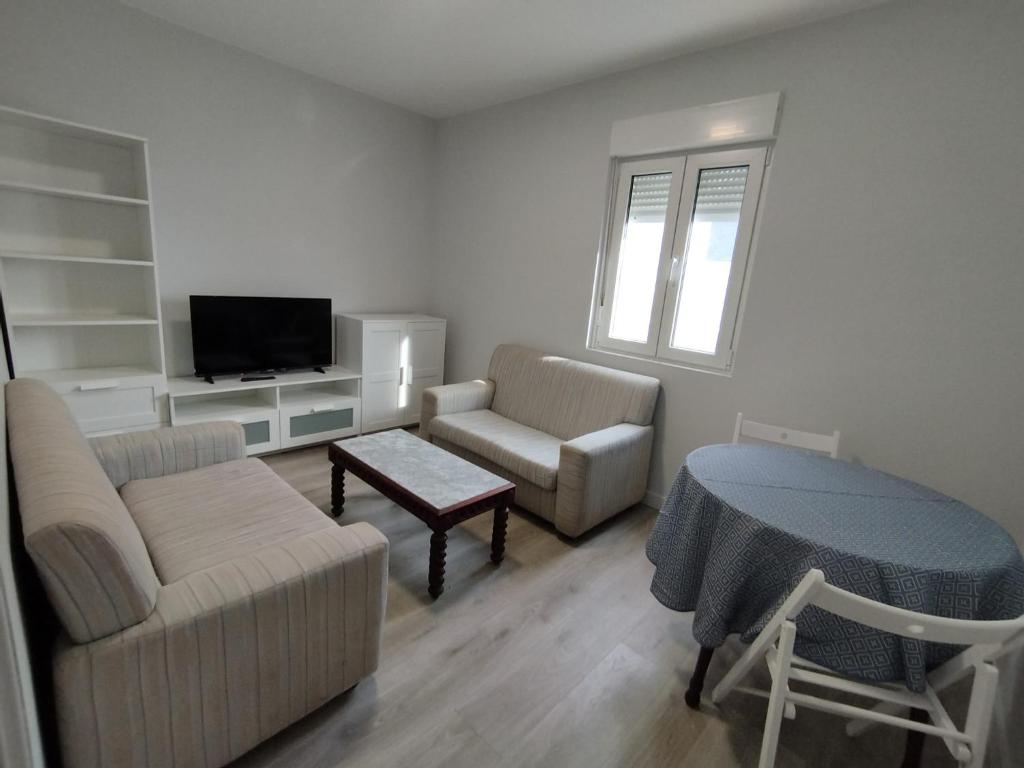 a living room with a couch and a tv at Oktheway Corme in Corme-Puerto