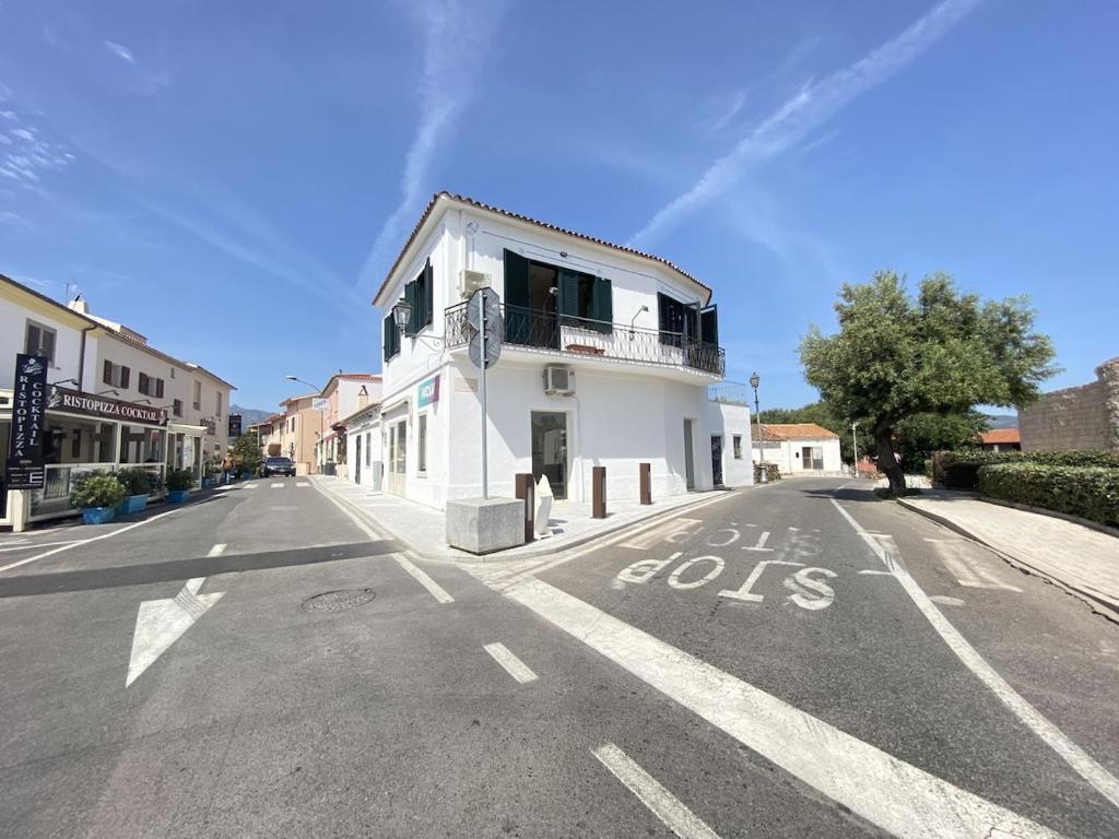 an empty street with a white building with the words no cars at Casa Passeri in San Teodoro