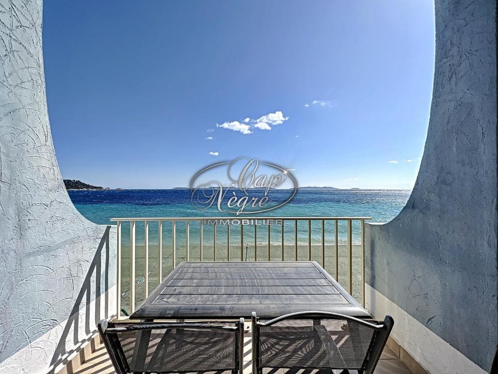 une table sur un balcon avec vue sur l'océan dans l'établissement studio pieds dans leau vue mer pour 2 personnes plage de cavaliere, au Lavandou
