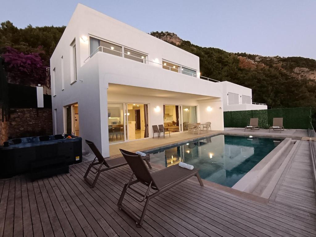 a white house with a swimming pool in front of it at Charming Villa with a Pool in Alanya