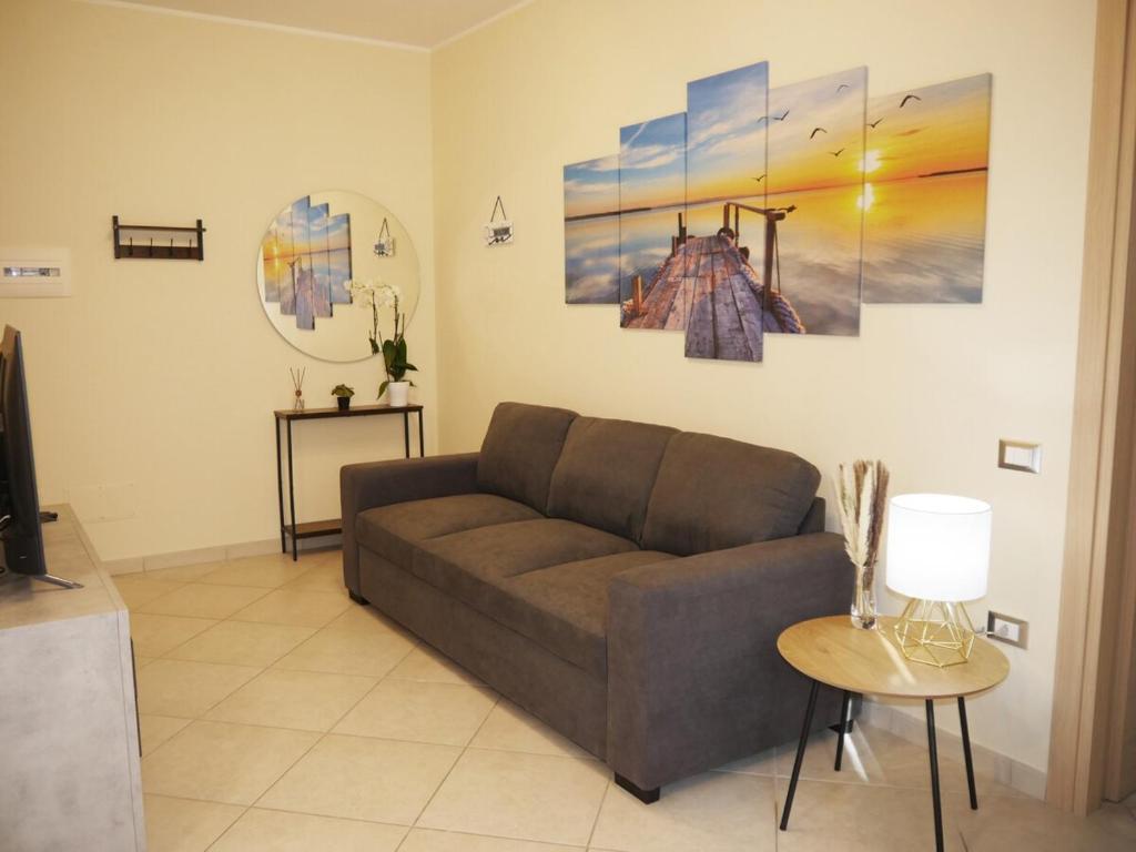 una sala de estar con un sofá y una mesa en Modern Two-Bedroom Flat, 10 Mins Walk To The Beach, en Quartu SantʼElena