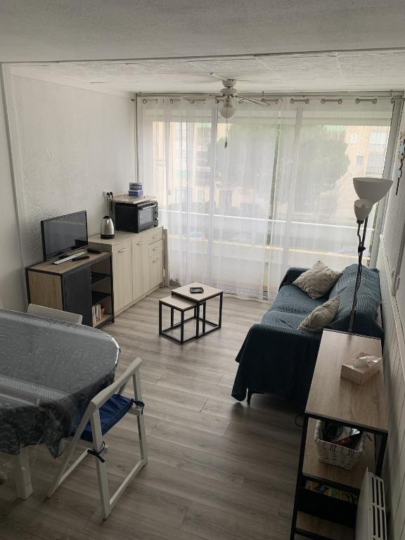 un salon avec un lit et une télévision dans l'établissement Sol-y-Days Floralies, grand duplex 6 personnes proche des plages, au Grau-du-Roi