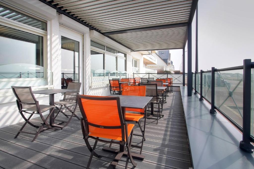 a row of tables and chairs on a balcony at Hôtel La Petite Sirène Quiberon in Quiberon