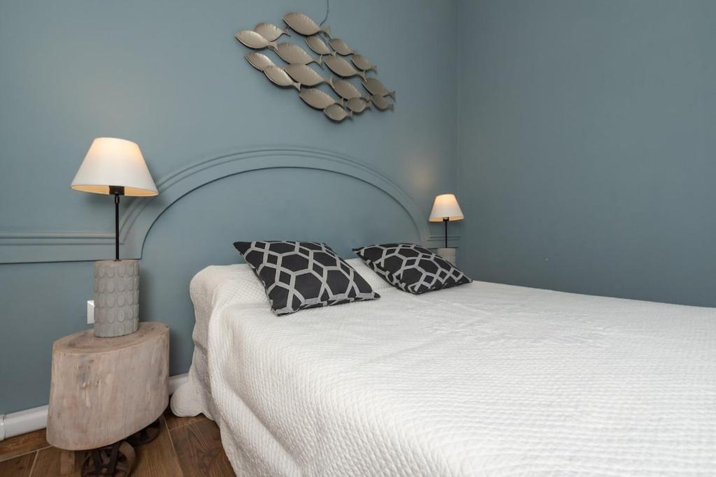 a bedroom with a white bed with two pillows at Appartamento Confortevole nel cuore del centro storico in Orosei