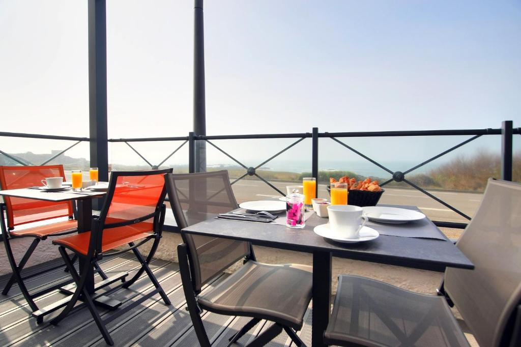 a table and chairs on a balcony with a view at Hôtel La Petite Sirène Quiberon in Quiberon