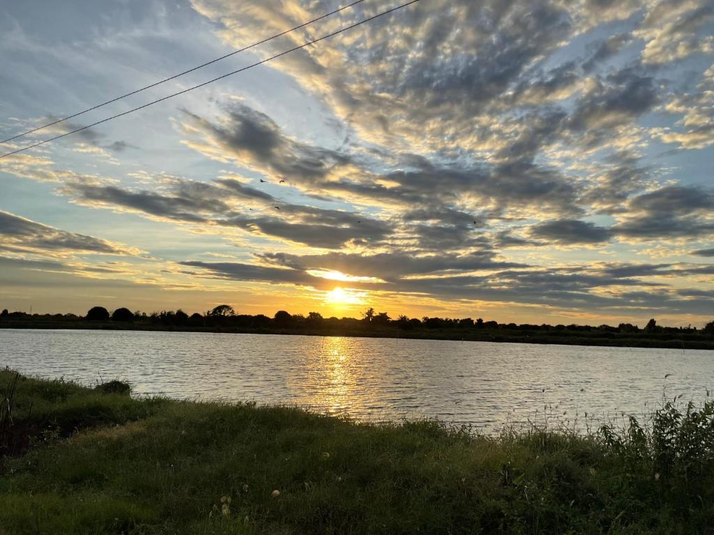 a sunset over a body of water with the sun setting at Countryside Rainbow Sweet Home Freshy Pets in Ban Tha Pho