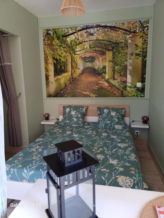 a bedroom with a bed with a picture on the wall at L'intervalle des 18 châteaux in Saint-Georges-sur-Cher
