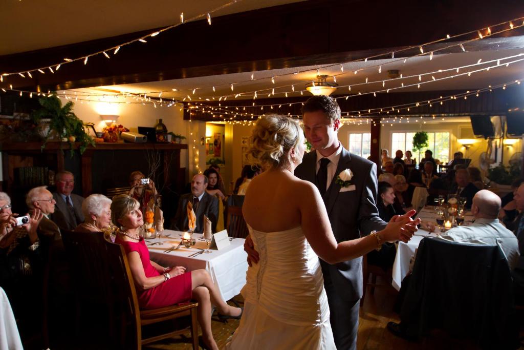 Una novia y un novio caminando por el pasillo en su boda en The Cove Inn, en Westport