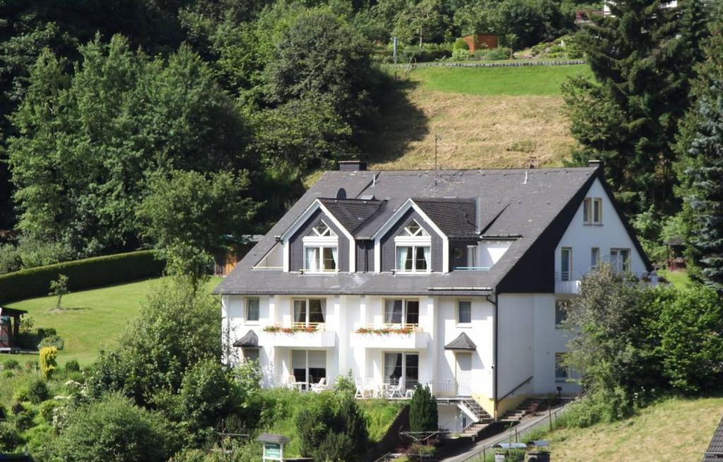 a large white house with a black roof at Appartementhaus Vierjahreszeiten in Willingen