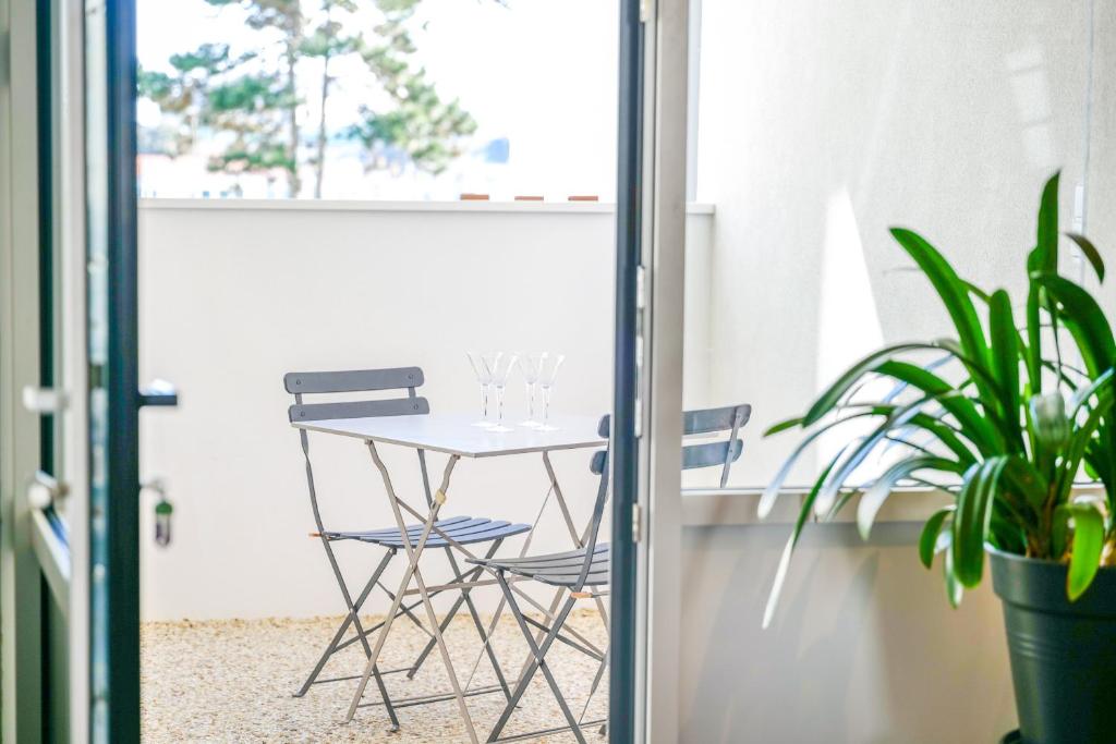 une table et deux chaises sur un balcon dans l'établissement charmante maisonnette proche chenal - 5 personnes, à Les Sables-dʼOlonne