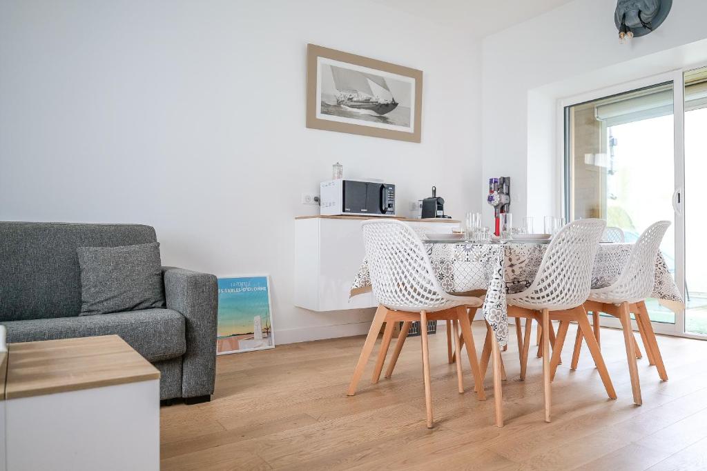 un salon avec une table, des chaises et un canapé dans l'établissement Maison de pêcheur rénovée - 3 chambres et patio extérieur - 6 personnes, à Les Sables-dʼOlonne