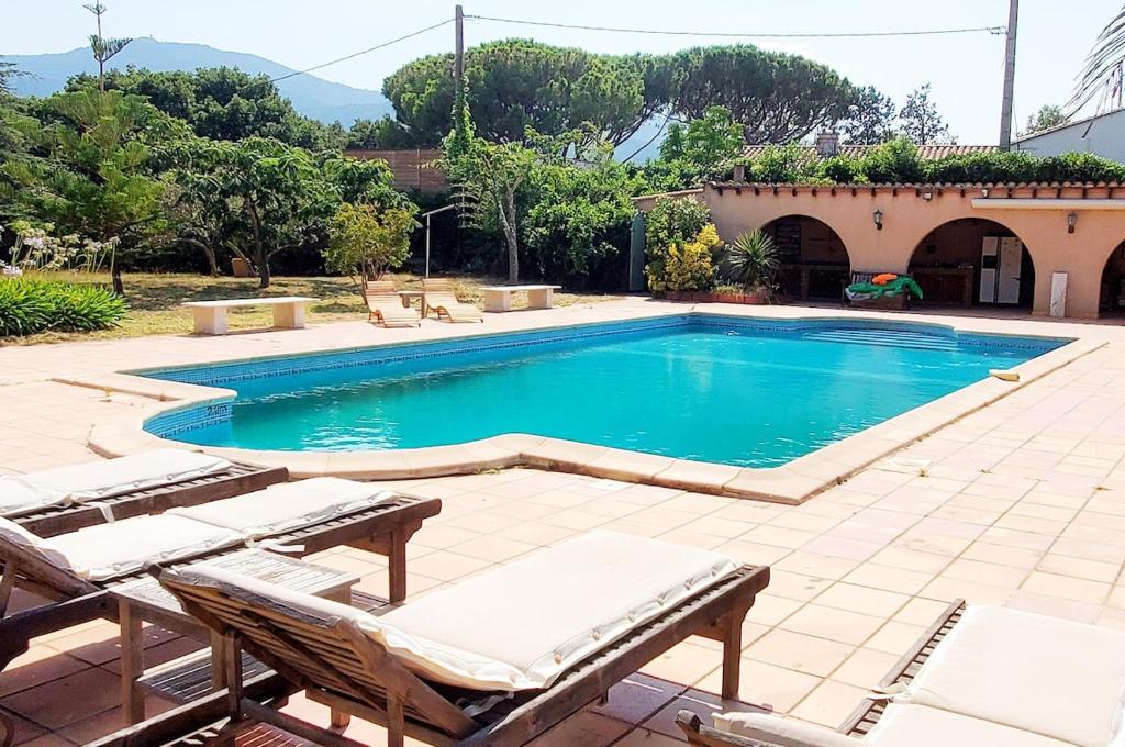 - une piscine avec 2 chaises longues devant une maison dans l'établissement Argelès, Sea View & Pool, à Argelès-sur-Mer