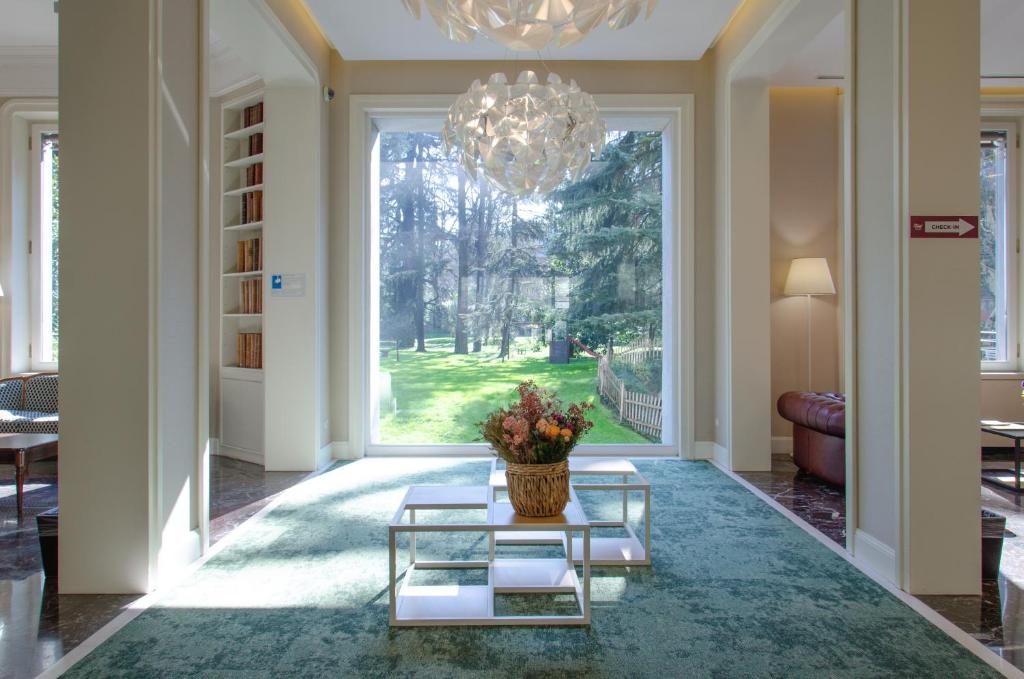 salon z dużym oknem i żyrandolem w obiekcie Hotel Tiziano - Gruppo Mini Hotel w Mediolanie