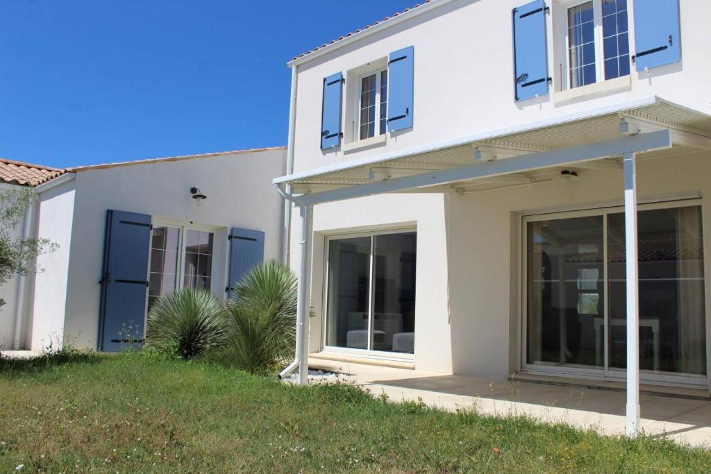 une maison blanche avec de grandes portes coulissantes en verre dans l'établissement Maison 5 pièces 8 couchages Saint Pierre d'Oléron SPO000-123, à Saint-Pierre-dʼOléron