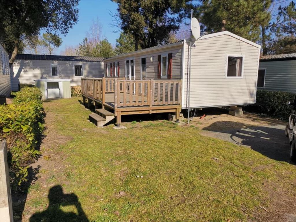 une maison avec une terrasse et une cour avec une maison dans l'établissement Bungalow convivial près de Saint-Jean-de-Monts avec jardin_2, à Saint-Jean-de-Monts
