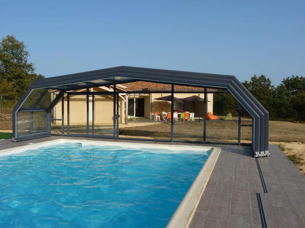 un pavillon avec une piscine en face d'une maison dans l'établissement La maison fitness, à Castang