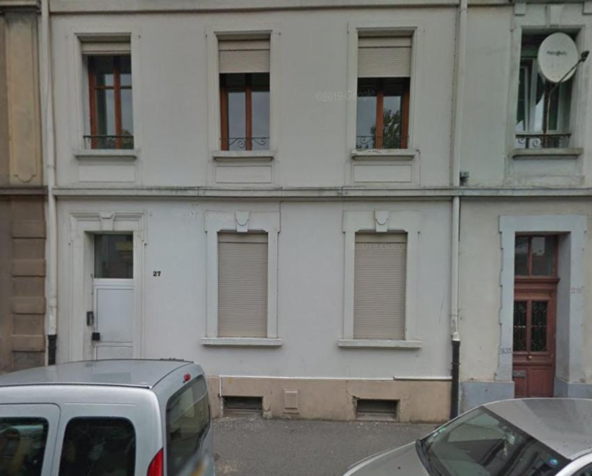 un bâtiment blanc avec des fenêtres et une camionnette garée devant dans l'établissement Bel appartement 3Pers Stationnement Gratuit Centre, à Mulhouse