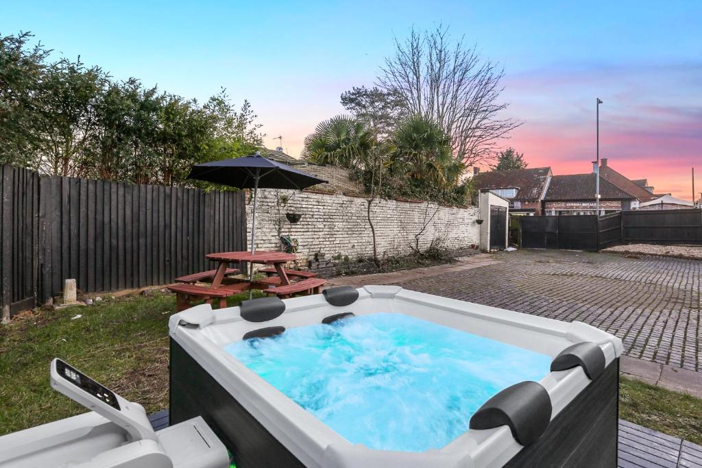 a hot tub in a yard with a picnic table at Hot Tub Stay Near Windsor & Legoland Sleeps 14 in Windsor