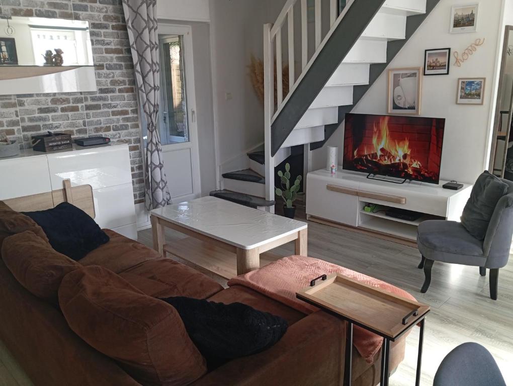 a living room with a couch and a fireplace at La Petite Maison Cosy in Saint-Sauveur-le-Vicomte