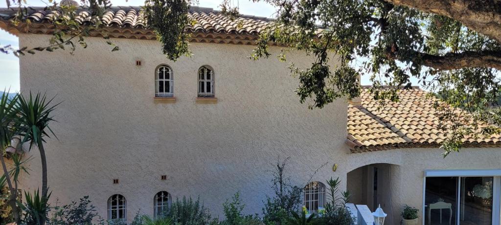 - un grand bâtiment blanc avec des fenêtres et un toit dans l'établissement Villa Bastide provençale Saint Raphaël Valescure, à Saint-Raphaël