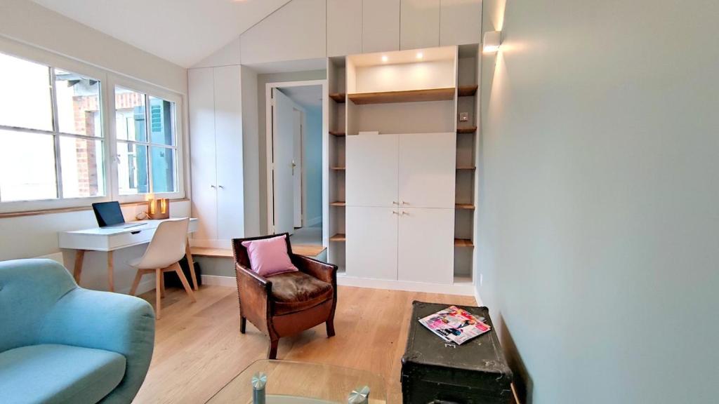Una sala de estar con un sofá, una silla y un escritorio. en Charming House - Ideal for Families, en Versalles
