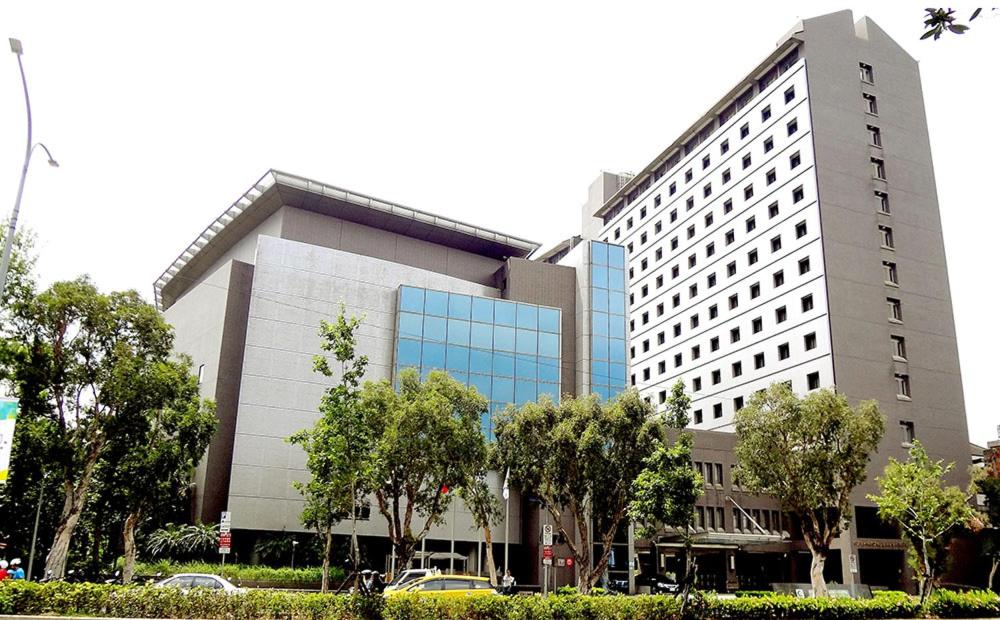 a large white building with trees in front of it at Howard Civil Service International House in Taipei