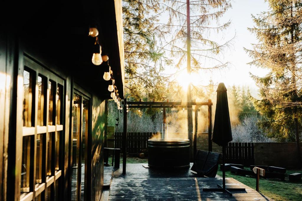 a patio with a table and chairs and the sun shining at Fabryka Snów loft w sercu Beskidów in Istebna