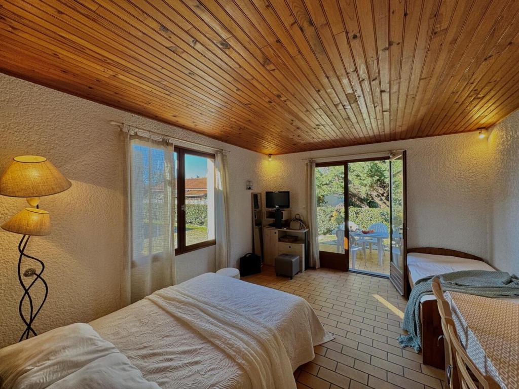 une chambre avec deux lits et un plafond en bois dans l'établissement Colibri - Studio à 500m des plages, à Mimizan-Plage