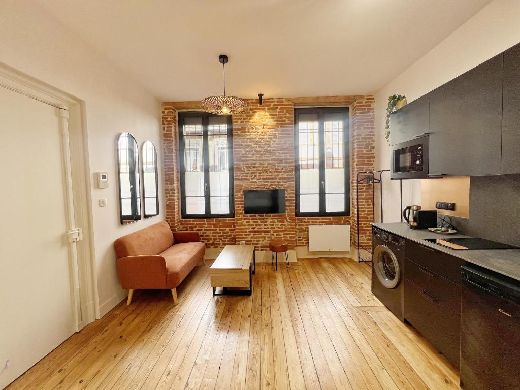 un salon avec un canapé et un mur de briques dans l'établissement L'Argentier - Centre - Luxe - Gare, à Toulouse