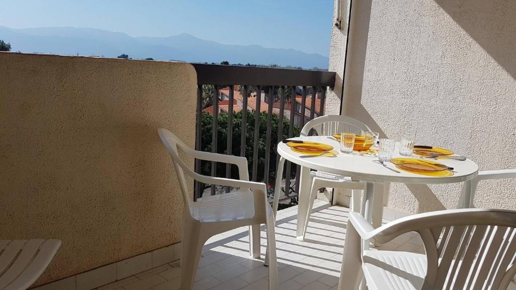 une table blanche et des chaises sur un balcon dans l'établissement Proche port et plage T2 dans résidence avec ascenseur parking-4CA403, à Saint Cyprien Plage
