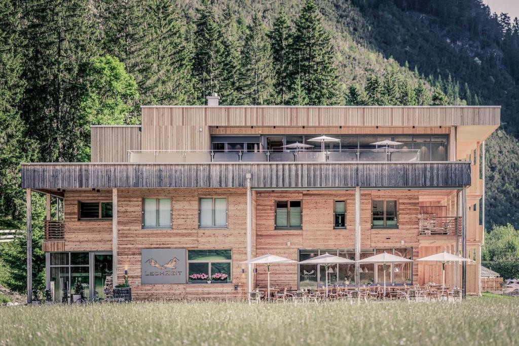 ElmenにあるBoutique Hotel LechZeitの建物の前にテーブルと傘
