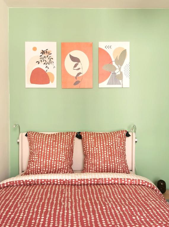 une chambre avec un lit avec quatre tableaux au mur dans l'établissement Lovely and bright studio in Montmartre, à Paris